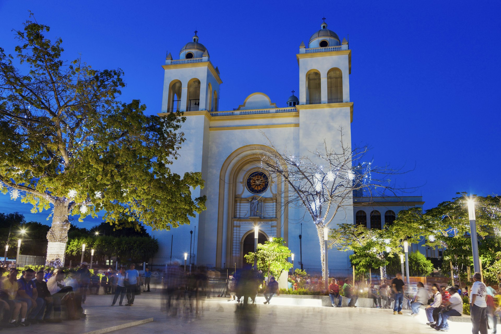 People walking  by San Salvador Cathedral on Plaza Barrios at evening